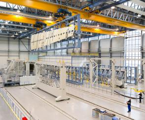 Cranes with latching devices for trolley transfer to link working areas