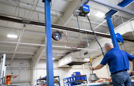 Demag D-BP two air balancer with an operator lifting a load using clean air power.