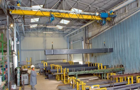 EPDE suspension cranes with rolled-profile girders and two DC-Pro chain hoists operating in tandem for handling long material in a store