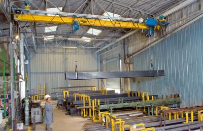 EPDE suspension cranes with rolled-profile girders and two DC-Pro chain hoists operating in tandem for handling long material in a store